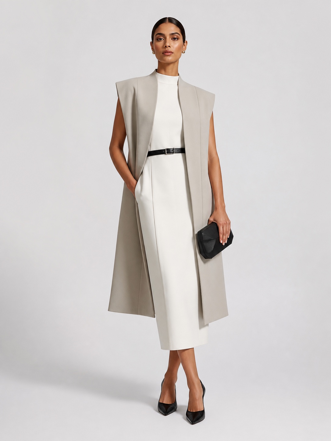 Woman in a porcelain column dress and architectural greige long vest